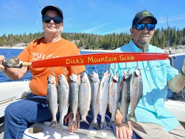 Two anglers showing off a full stringer of rainbow trout from Bass Lake