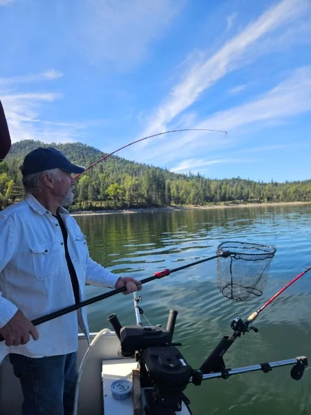 Mike Beighey netting a trout on Bass Lake